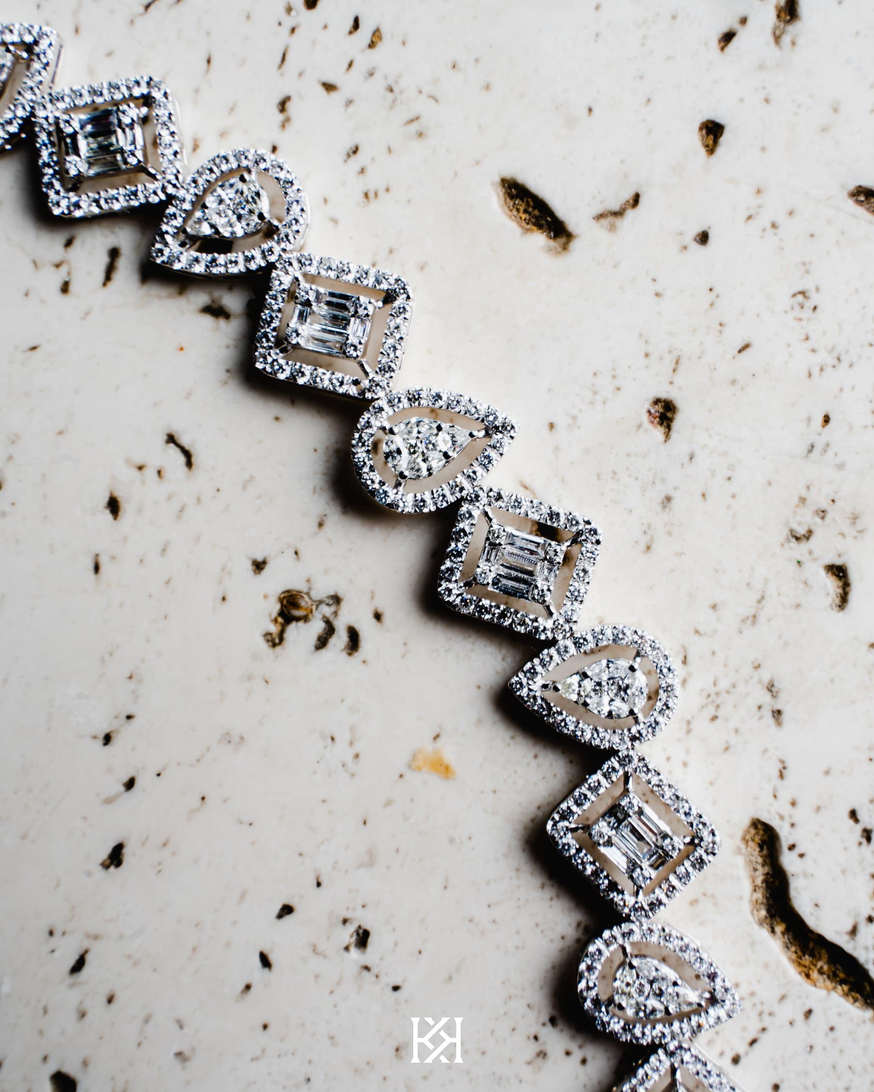 Close product photography of a diamond-set watch bracelet on a pale ground.